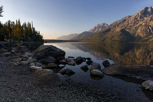 gravel pile of stones beside body of water road